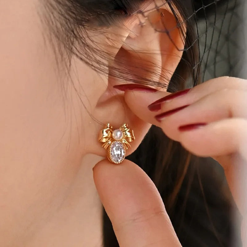 Alice Bow Stud Earrings - Lovely, delicate gold earrings shaped like a stylised bow, punctuated with a tiny pearl in the centre and a sparkling white quartz below.