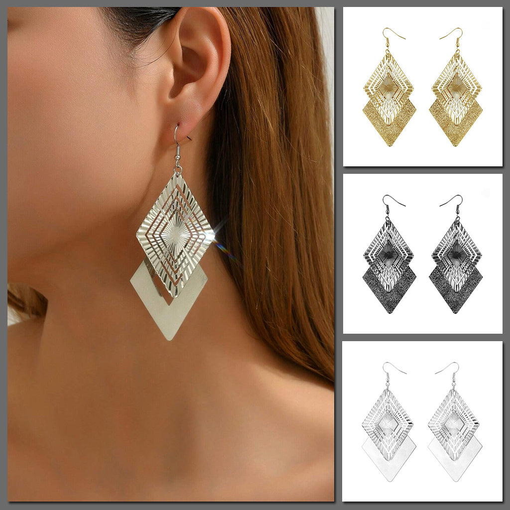 Allegra Geometric Cut-Out Drop Earrings - Large metallic earrings constructed of two overlapping diamond shapes, one with a geometric angular pattern and one with a simpler texture.