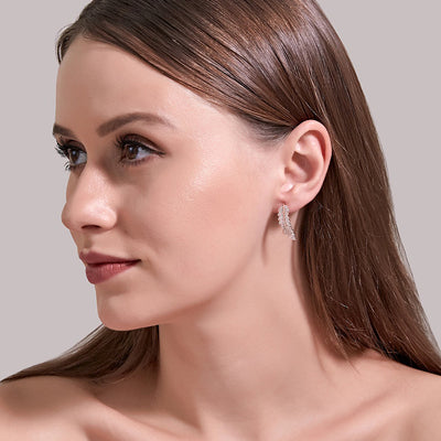 Angelina Feather Crystal Studs Earrings - A tiny stud earring that looks like a stylised feather or fern frond studded with crystals, available in yellow, rose, or white gold.