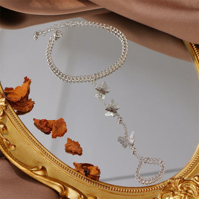 Anjana Butterfly Hand Chain Bracelet - A simple hand chain with a loop around the wrist and one around the finger, and a length of finer chain between the two decorated with tiny butterfly charms.
