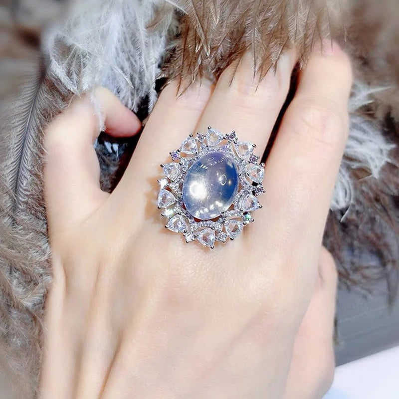 Arabelle Luxury Crystal Adjustable Ring - A large cocktail ring featuring a single blue-white opal surrounded by a cluster of elegantly-carved quartz crystals.