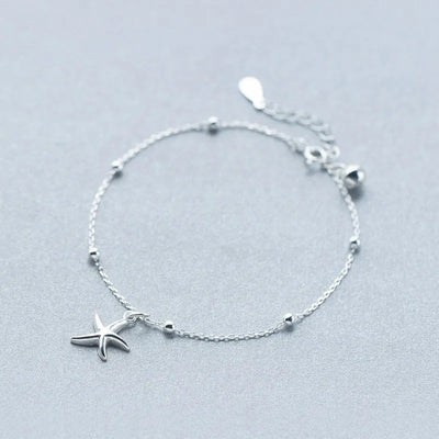 Ariel Starfish Charm Bracelet - A very delicate silver-coloured chain bracelet adorned with a tiny starfish charm and a cute little bell.