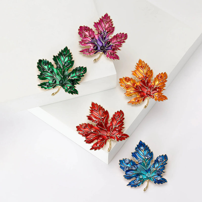 Aurelia Maple Leaf Enamel Brooch - A large, colourful enamel brooch shaped like a stylised maple leaf, studded with coloured crystals and metallic enamel paint.