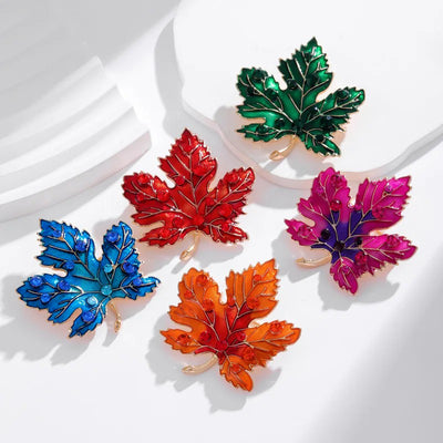 Aurelia Maple Leaf Enamel Brooch - A large, colourful enamel brooch shaped like a stylised maple leaf, studded with coloured crystals and metallic enamel paint.