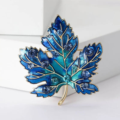 Aurelia Maple Leaf Enamel Brooch - A large, colourful enamel brooch shaped like a stylised maple leaf, studded with coloured crystals and metallic enamel paint.