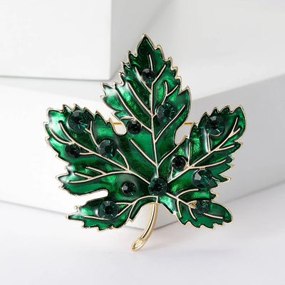 Aurelia Maple Leaf Enamel Brooch - A large, colourful enamel brooch shaped like a stylised maple leaf, studded with coloured crystals and metallic enamel paint.