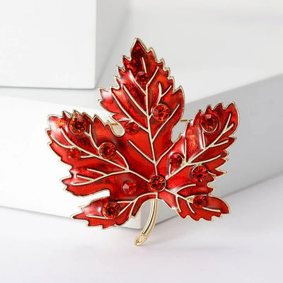 Aurelia Maple Leaf Enamel Brooch - A large, colourful enamel brooch shaped like a stylised maple leaf, studded with coloured crystals and metallic enamel paint.