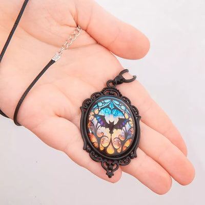 Batty Bat Cameo Necklace - A large gothic glass cabochon featuring an image of a stylized bat against an orange-blue ombre background.