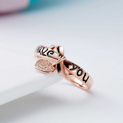 Be Still My Heart Ring - A rose gold ring with a heart and ribbon theme.