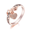 Be Still My Heart Ring - A rose gold ring with a heart and ribbon theme.