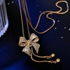 Bethany Bowknot Adjustable Sweater Chain - A long, slender snake chain with a stylised pave bow pendant set on it, which can be adjusted so the chains hang different lengths.
