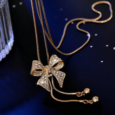 Bethany Bowknot Adjustable Sweater Chain - A long, slender snake chain with a stylised pave bow pendant set on it, which can be adjusted so the chains hang different lengths.