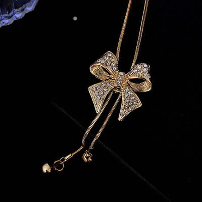 Bethany Bowknot Adjustable Sweater Chain - A long, slender snake chain with a stylised pave bow pendant set on it, which can be adjusted so the chains hang different lengths.