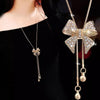 Bethany Bowknot Adjustable Sweater Chain - A long, slender snake chain with a stylised pave bow pendant set on it, which can be adjusted so the chains hang different lengths.