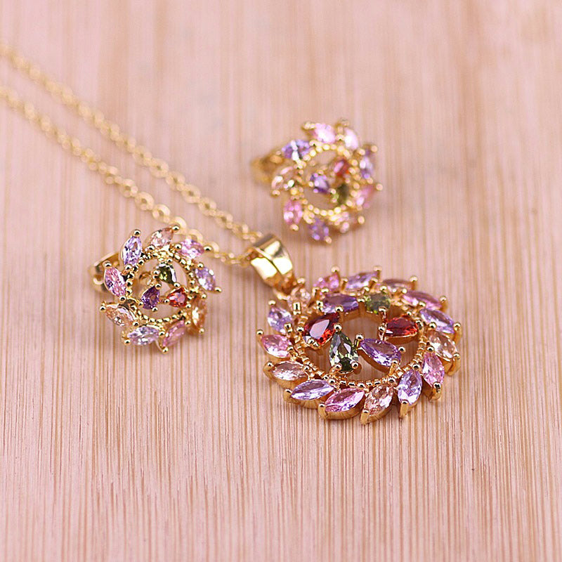 Bijoux Rosette Nebula Pendant & Earrings Set - A jewellery set consisting of a matching necklace and pendant, featuring multi-coloured crystals set in contrasting circular patterns that resemble a nebula.