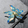 Brigette Orchid Sculpted Resin Brooch - An elegant floral brooch available in blue, pink, or purple, with shimmering crystals and semi-translucent resin.