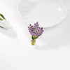 Brighid Lavender Sprig Brooch - A medium-sized crystal brooch shaped like a trio of delicate sprigs of lavender tied together, featuring lovely purple, green, and white crystals.