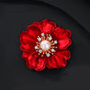 The Carmine Enamel Poppy Brooch - A vibrant, bright red round poppy brooch with sparkling crystals and a pearl in the centre.