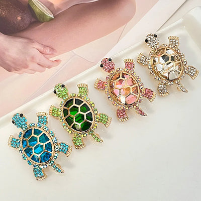 Caspia Crystal Turtle Brooch - A large stylised turtle brooch, composed of a single large, oval-shaped crystal encased in a shell of golden-coloured metal, and surrounded by lots of tiny matching crystals.