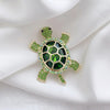 Caspia Crystal Turtle Brooch - A large stylised turtle brooch, composed of a single large, oval-shaped crystal encased in a shell of golden-coloured metal, and surrounded by lots of tiny matching crystals.
