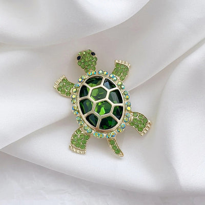 Caspia Crystal Turtle Brooch - A large stylised turtle brooch, composed of a single large, oval-shaped crystal encased in a shell of golden-coloured metal, and surrounded by lots of tiny matching crystals.