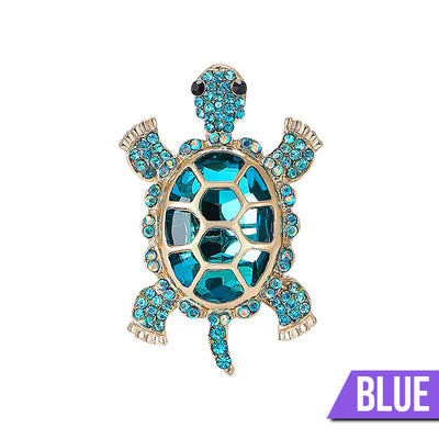 Caspia Crystal Turtle Brooch - A large stylised turtle brooch, composed of a single large, oval-shaped crystal encased in a shell of golden-coloured metal, and surrounded by lots of tiny matching crystals.