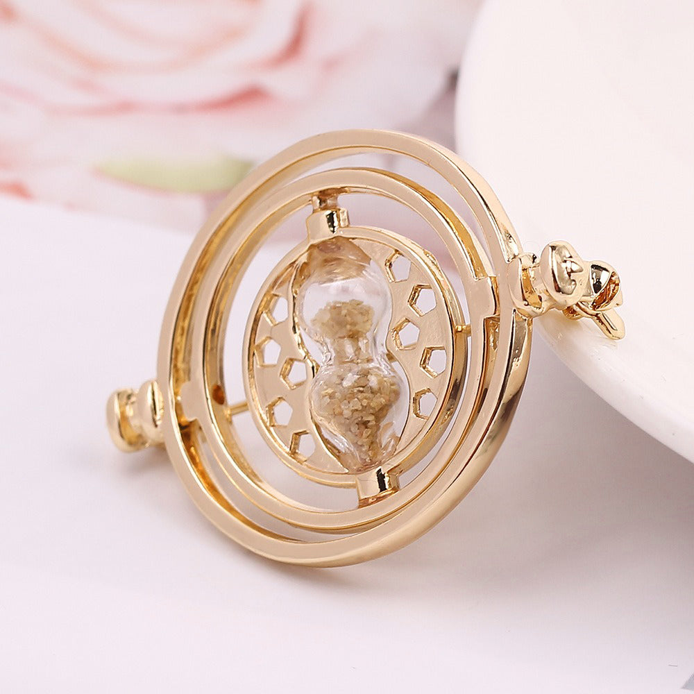 Cheeky Geek Time Turner Brooch - A small golden brooch with an hourglass in the centre, inspired by the Time Turner magical device from the Harry Potter series.