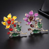 Citrika Orange Blossom Brooch - A detailed floral brooch featuring a large central stone with ruffled enamel petals surrounding it, and lots of colourful crystals to really make it pop.