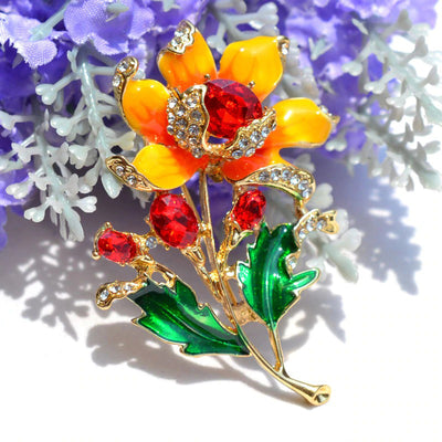 Citrika Orange Blossom Brooch - A detailed floral brooch featuring a large central stone with ruffled enamel petals surrounding it, and lots of colourful crystals to really make it pop.