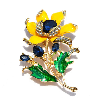 Citrika Orange Blossom Brooch - A detailed floral brooch featuring a large central stone with ruffled enamel petals surrounding it, and lots of colourful crystals to really make it pop.