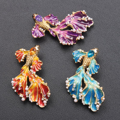 Cleo Double Tail Betta Fish Brooch - Three elegant stylised fish brooches adorned with tiny crystals and pearls, available in blue, orange, or purple colour palettes.