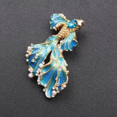 Cleo Double Tail Betta Fish Brooch - Three elegant stylised fish brooches adorned with tiny crystals and pearls, available in blue, orange, or purple colour palettes.