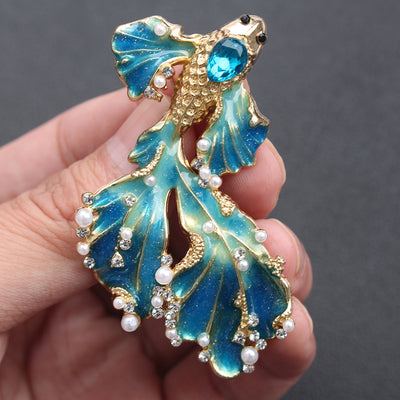 Cleo Double Tail Betta Fish Brooch - Three elegant stylised fish brooches adorned with tiny crystals and pearls, available in blue, orange, or purple colour palettes.