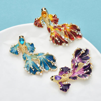 Cleo Double Tail Betta Fish Brooch - Three elegant stylised fish brooches adorned with tiny crystals and pearls, available in blue, orange, or purple colour palettes.