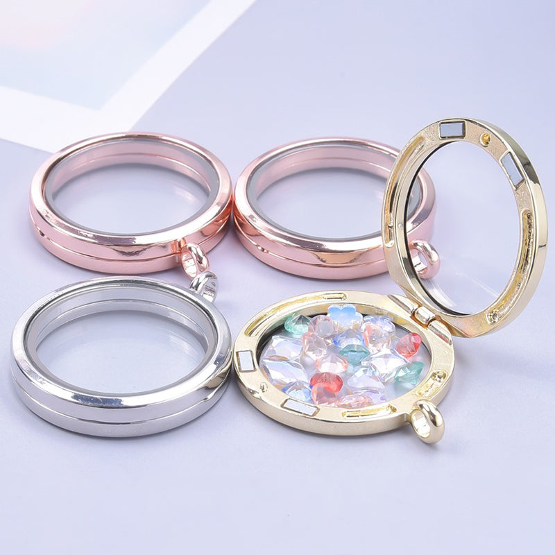 Clio Magnetic Floating Locket - A 3cm metal locket with glass on the front and back, so that anything placed between the two panels can be seen from both sides. Available in gold, gunmetal (dark silver), rose gold, or silver coloured. It comes with a chain.