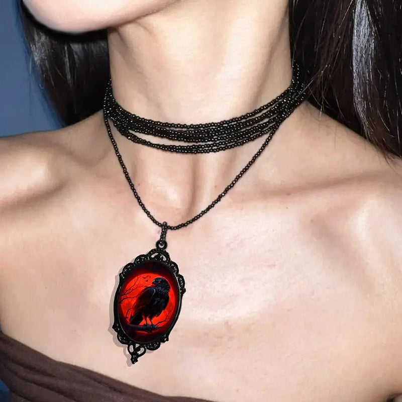Crimson Corvid Cameo Necklace - A large gothic glass cabochon featuring an image of a black raven against a bright red background.