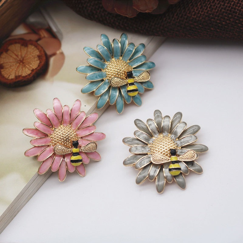 Cute Critters Brooch - Bumblebloom II - A 35mm round stylised flower brooch with a cute little bumble bee charm attached to it, available in pink, blue, or dark grey.