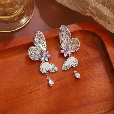 The Cynthia Butterfly Crystal Earrings - Sparkling silver butterfly wing earrings with purple and white crystals.