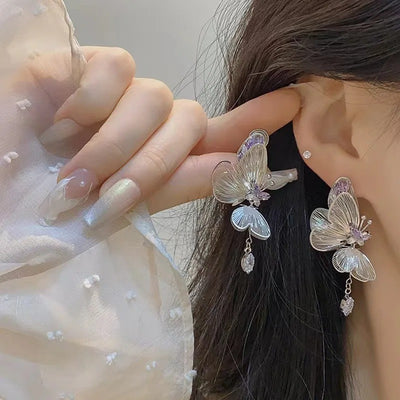 The Cynthia Butterfly Crystal Earrings - Sparkling silver butterfly wing earrings with purple and white crystals.