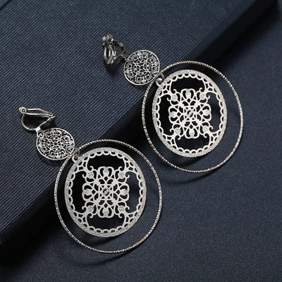 Devani Filigree Disc Clip Earrings - Metal clip-on earrings made from a series of interlocking metal circles, with an embossed filigree pattern.