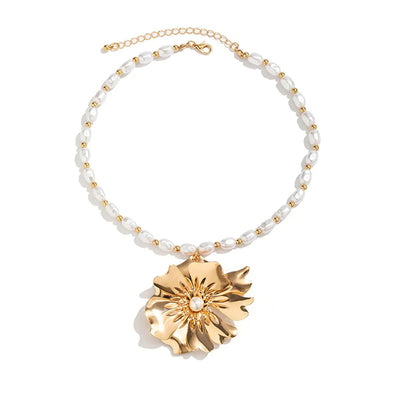 Ebele Oversized Flower Necklace - A strand of elegant oval-shaped pearls, with a large golden-coloured stylised flower pendant.