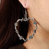 Elvira Barbed Wire Heart Drop Earrings - Large gothic earrings crafted from sculpted metal to resemble a heart-shape made of barbed wire and adorned with small flowers.