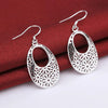 Emmaline Cut-Out Dangle Earrings - Delicate oval-shaped silver earrings with a floral cut-out pattern.