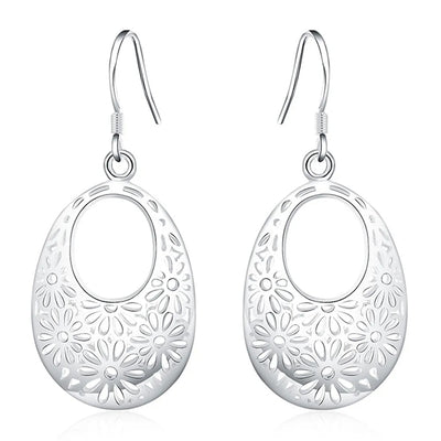 Emmaline Cut-Out Dangle Earrings - Delicate oval-shaped silver earrings with a floral cut-out pattern.