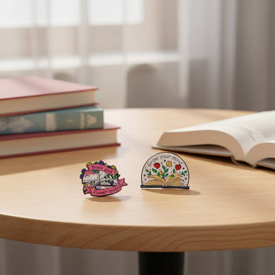 The "Book And Flower Lover" Enamel Pin is a tiny, but very stylish enamel pin, featuring a pile of stylised books wreathed in flowers and ribbons, along with simple letters proclaiming your love of said books and flowers. So cute! Grab yours today!