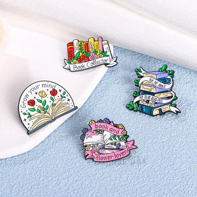The "Book And Flower Lover" Enamel Pin is a tiny, but very stylish enamel pin, featuring a pile of stylised books wreathed in flowers and ribbons, along with simple letters proclaiming your love of said books and flowers. So cute! Grab yours today!