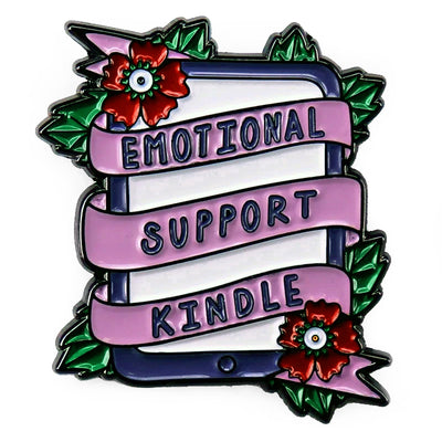 The "Emotional Support Kindle" Enamel Pin features a stylised Kindle eBook reader, adorned with a pink ribbon, green leaves, and red flowers in the corners.