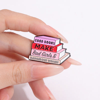 The "Good Books Make Bad Girls &amp; Dangerous Women" Enamel Pin is a small, stylish brooch featuring a stack of stylised books with text on the spines forming this very excellent and appropriate slogan. So true! Grab yours today!