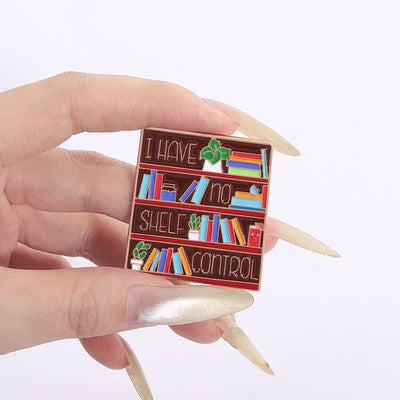 The "I Have No Shelf Control" Enamel Pin features a stylised bookshelf with large text proclaiming that you have no shelf control. So true.