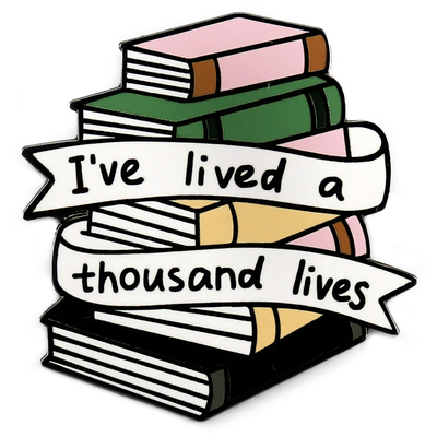 The "I've Lived A Thousand Lives" Enamel Pin features a stack of colourful stylised cartoon books, with a ribbon on the front announcing just how many fantastical lives you've lived. At least a thousand! Maybe more!